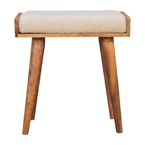 A cozy beige boucle cream tray style footstool with sheepskin cushion and natural wood tapered legs