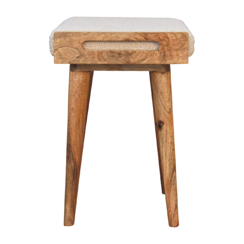 A rustic wooden tray style footstool with cream boucle upholstery and tapered legs perfect for extra seating