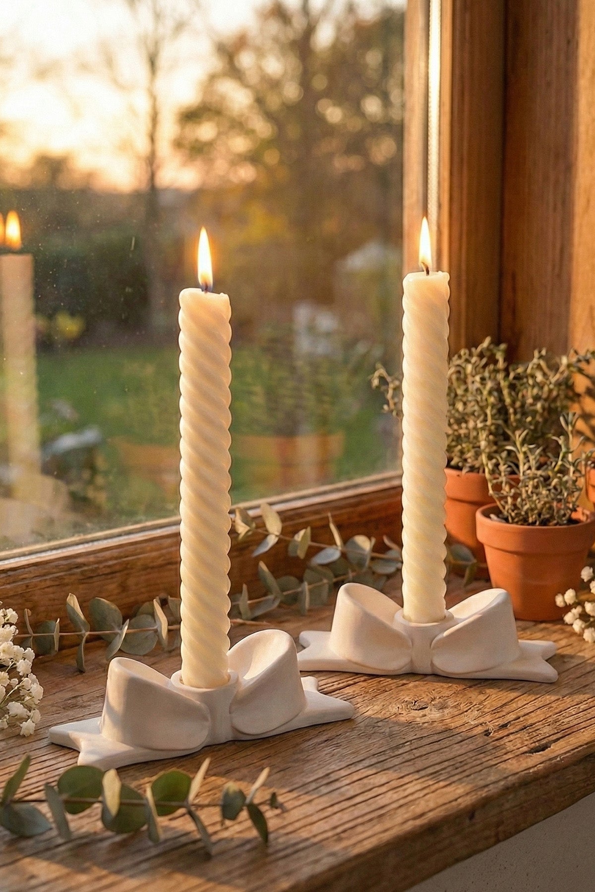 White ceramic bow candle holder with twisted cream taper candles made from jesmonite item perfect for decor