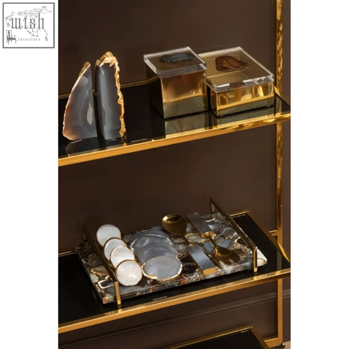Gold-framed glass shelf displaying polished black agate slices and geometric bowerbird black agate trinket box