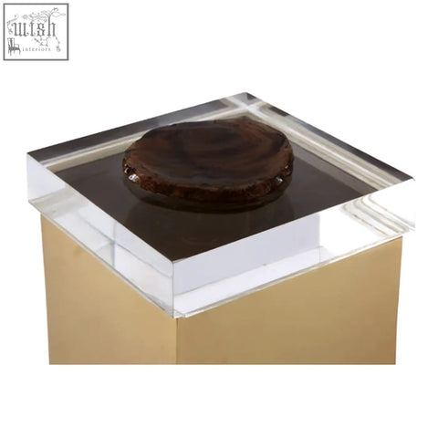 A bowerbird black agate small trinket box is a dark glossy circular black agate cake on a clear acrylic gold pedestal