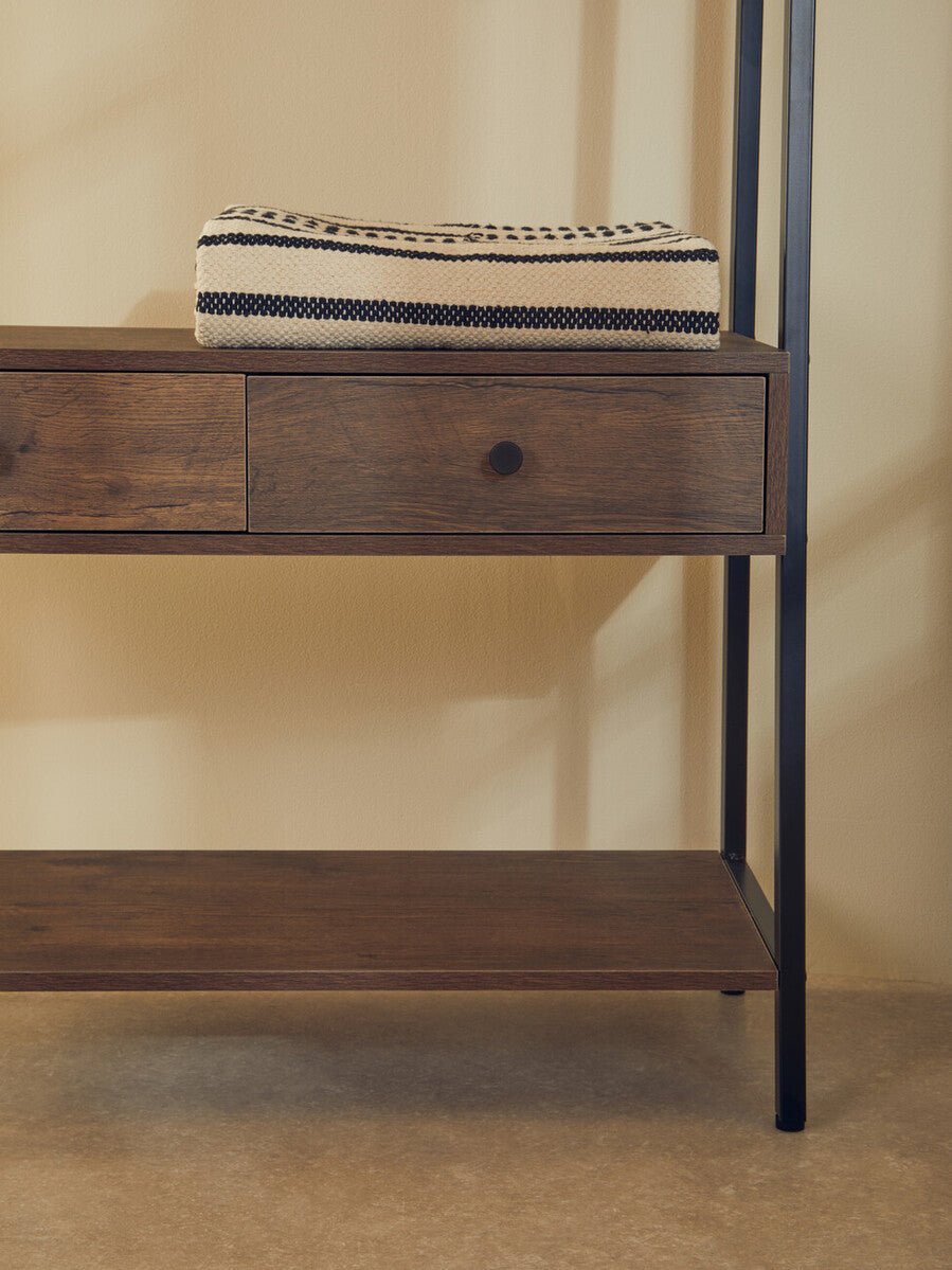 A folded cream and black woven blanket rests on a dark wood console table with metal legs in bradbury dark oak style
