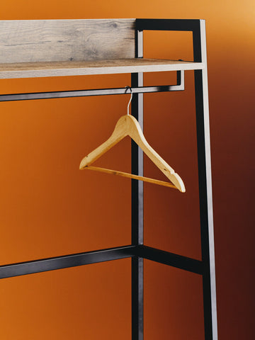 A simple light wooden hanger hangs inside the bradbury dark oak effect open wardrobe for sleek storage