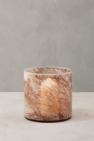 Branch medium glass hurricane candle holder with frosted glass and copper tree branch patterns holding a lit white candle