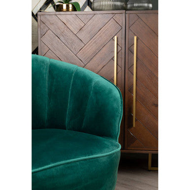 Emerald green velvet armchair with plush tufted backrest beside brando acacia wood effect drinks cabinet