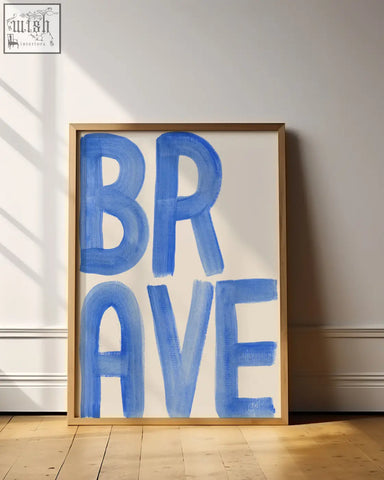 Brave word art print with blue brushstroke design in a light wood frame perfect for a gallery wall display