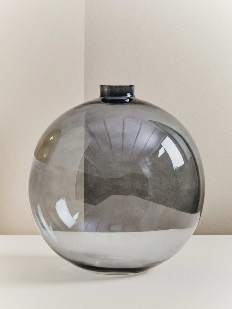 A sleek bree grey glass vase with a dark grey tint and smooth reflective surface perfect for home decor