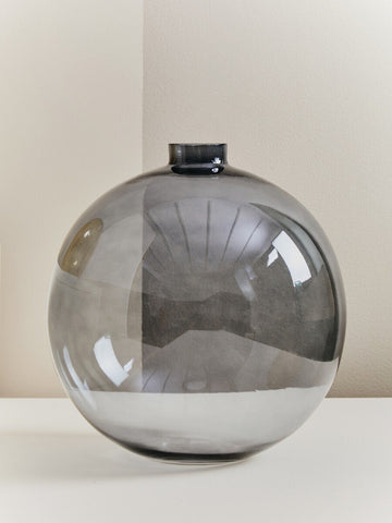 A sleek bree grey glass vase with a dark grey tint and smooth reflective surface perfect for home decor