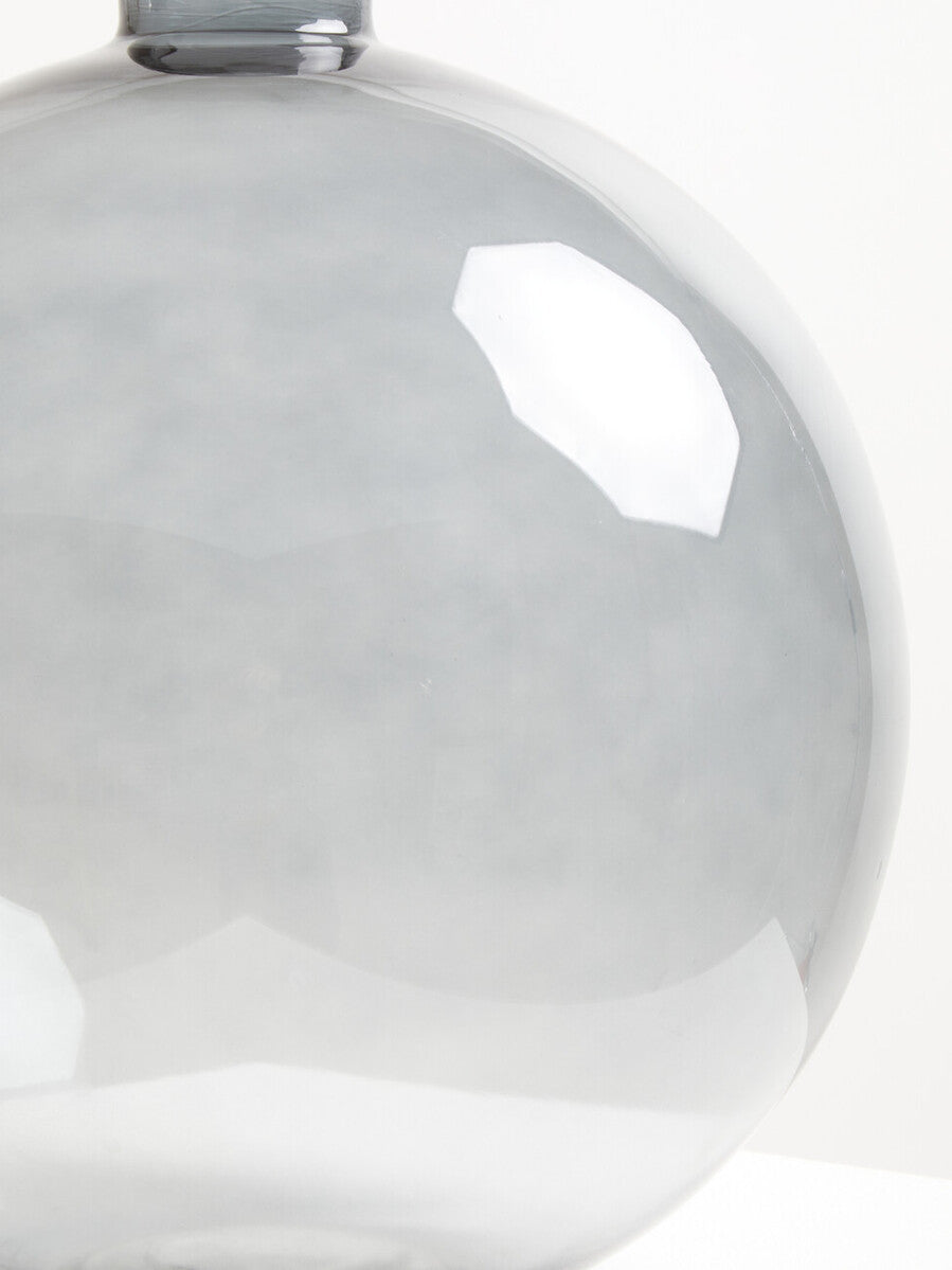 Bree grey glass vase with a sleek translucent grey glass body and smooth rounded shape with a metallic rim on top