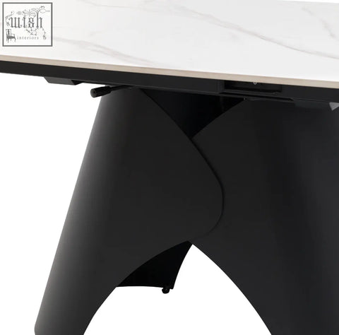 Black matte finished angular table leg supporting a white marble style tabletop on the Brezzo extendable dining table