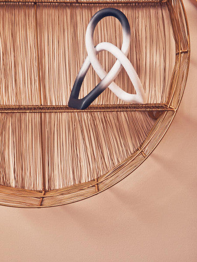 A sleek broc ombre black and white knot sculpture pendant shaped like a modern infinity knot