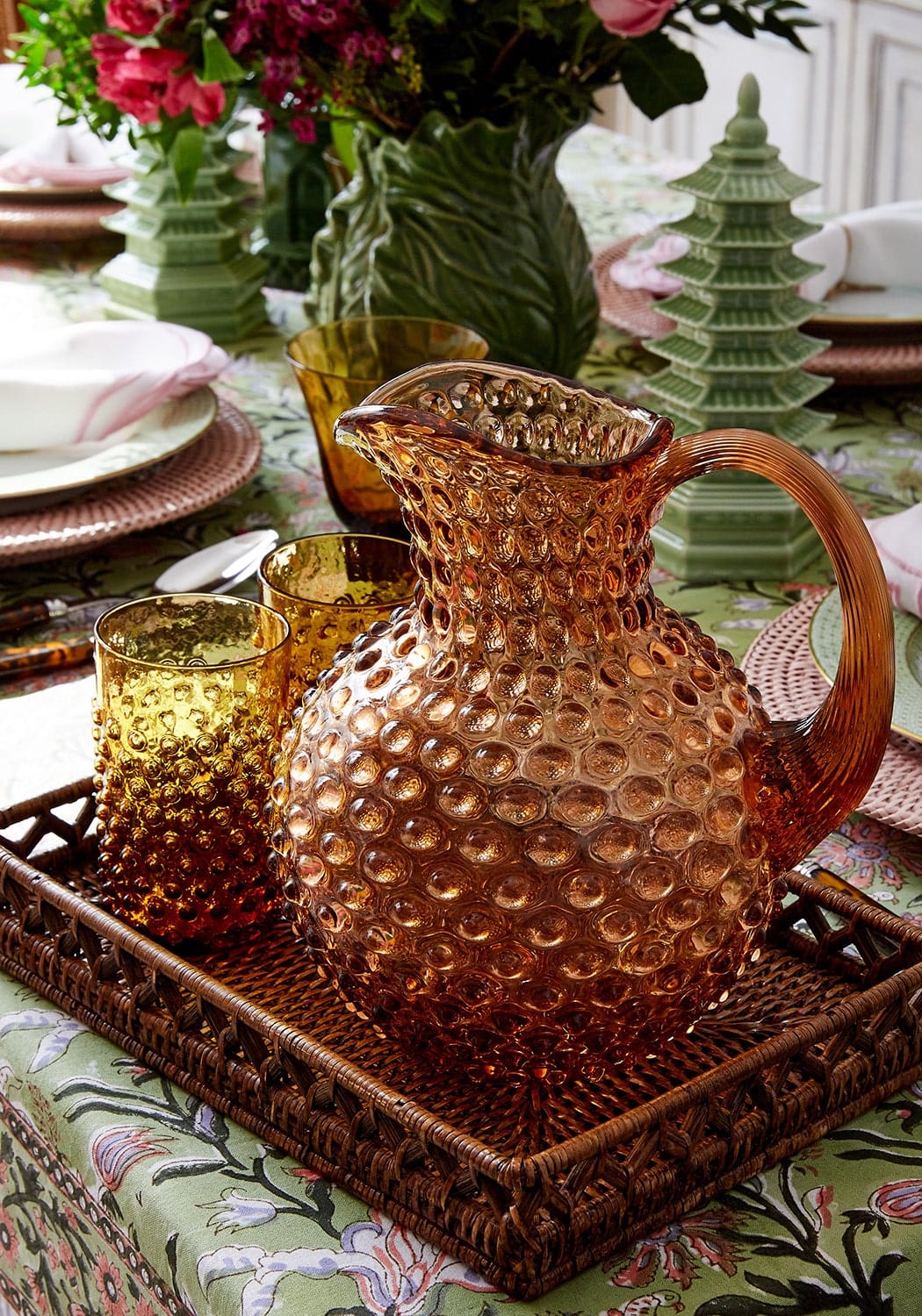 Amber-colored glass pitcher with textured bubble surface and ornate handle matching bronze dew drop tumblers set