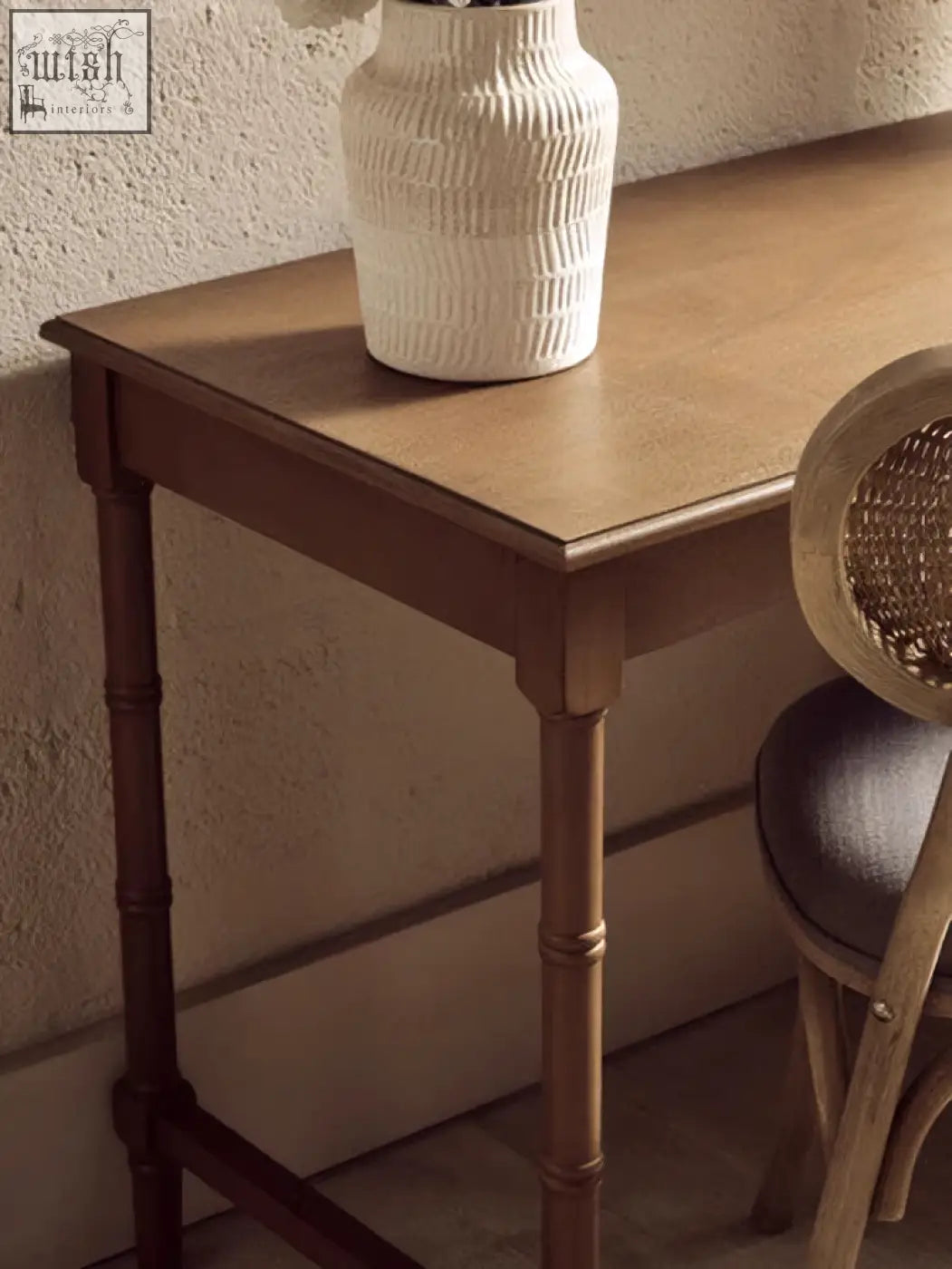 White textured ceramic vase with vertical ridged pattern on a brown pine wood console table with storage drawer and shelves