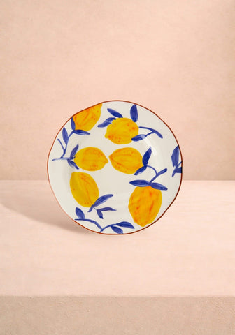 A white ceramic lunch plate hand painted with yellow lemons and blue leaves from buds in may set inspired by matisse