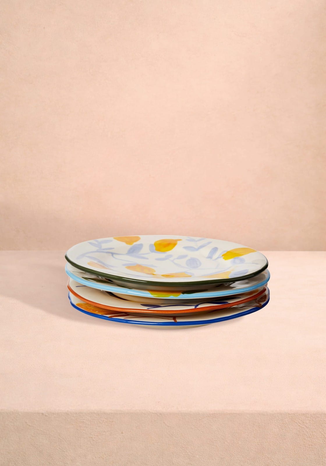 Stack of colorful ceramic lunch plates hand-painted with floral and citrus motifs inspired by matisse set of 4