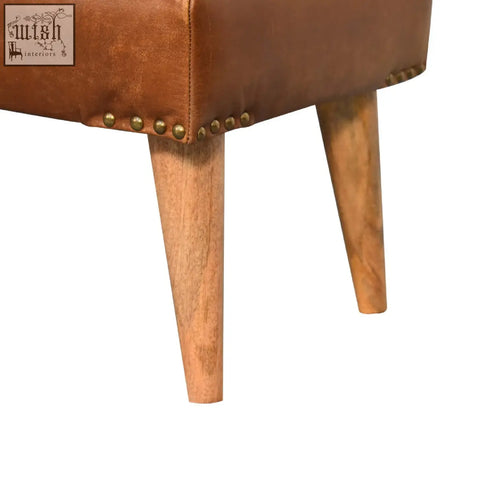 Tan buffalo hide leather bench with brass nailhead trim and tapered wooden legs perfect for seating
