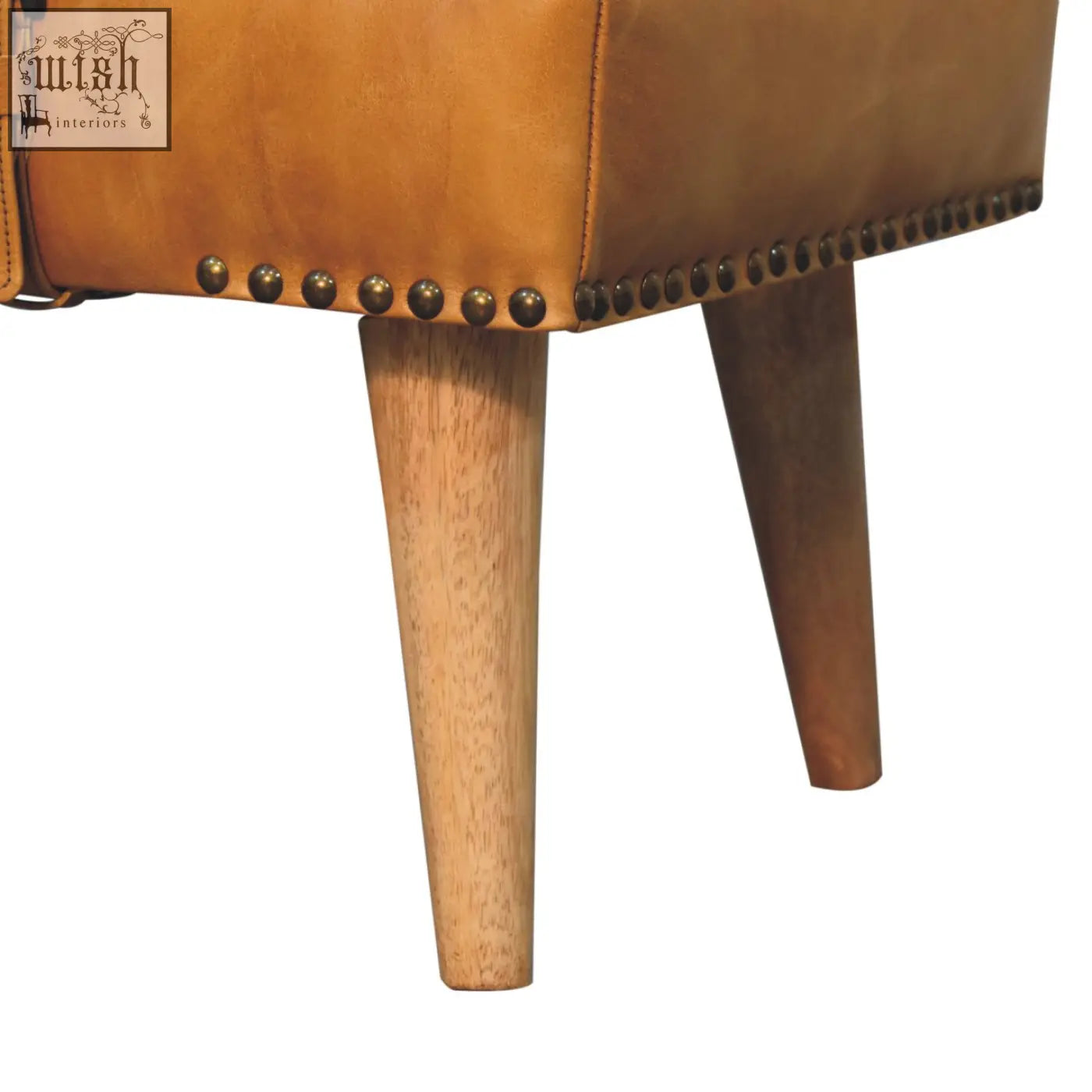 Tan leather stool with brass nailhead trim and tapered wooden legs paired with buffalo hide olive green bench