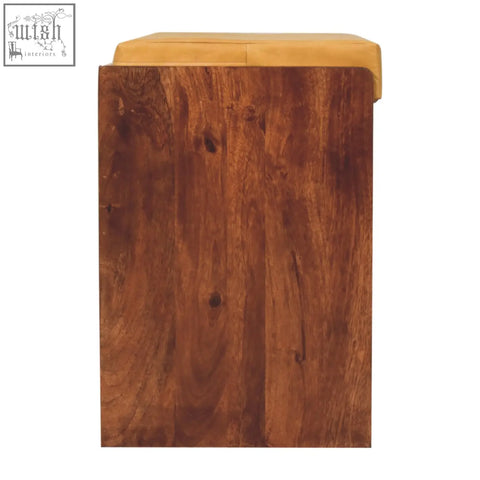 A rustic shoe storage bench with solid mango wood frame and tan upholstered seat for hidden shoe storage