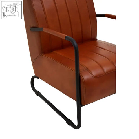 Buffalo tan leather armchair with brown tan leather upholstery and black metal frame with curved legs
