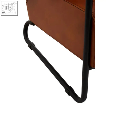 Brown leather side table with sleek black metal frame complements buffalo tan leather armchair in tan leather style