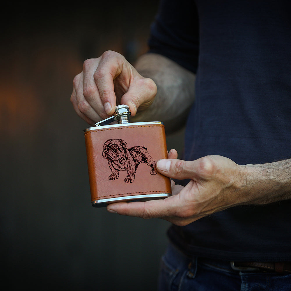 Brown leather hip flask with an engraved bulldog design and silver metal cap for stylish carrying