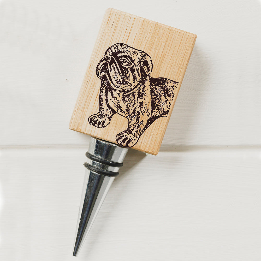 A light-colored wooden oak bottle stopper with a laser-engraved bulldog design and a metallic stem