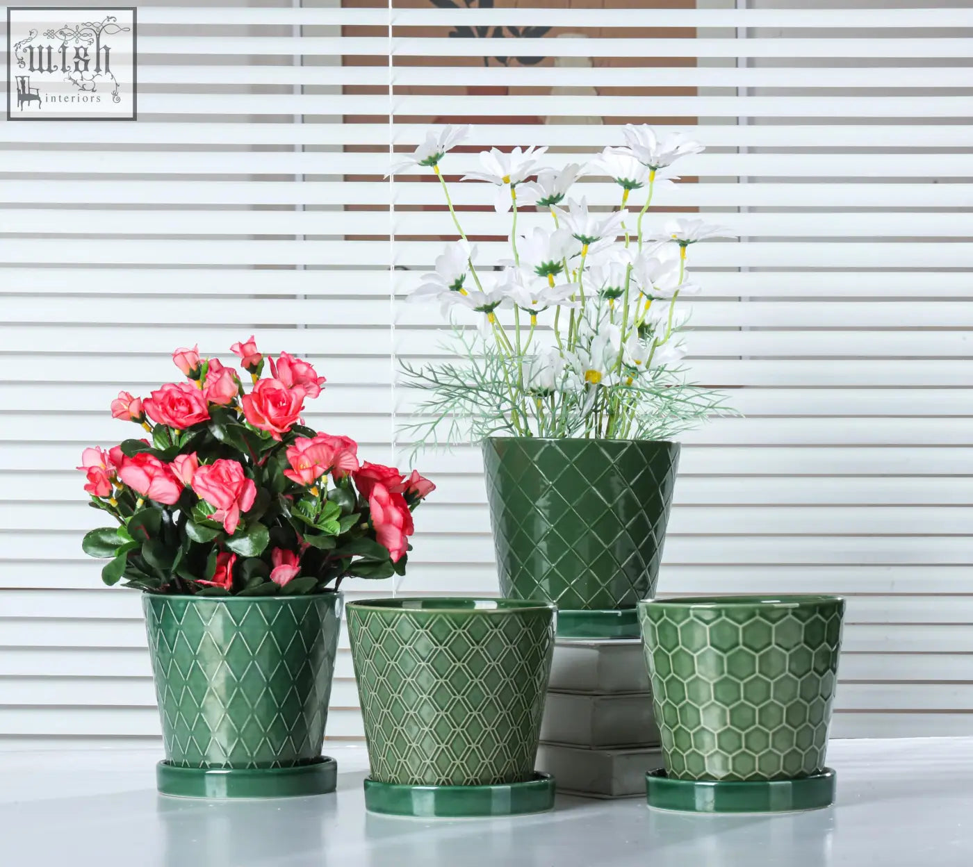 Set of three green ceramic plant pots with textured diamond and hexagonal patterns and drainage hole with saucers