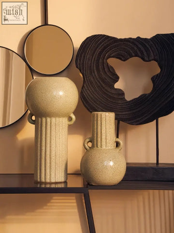 Two beige ceramic vases with textured surfaces and small handles featuring calcita large speckled green accents