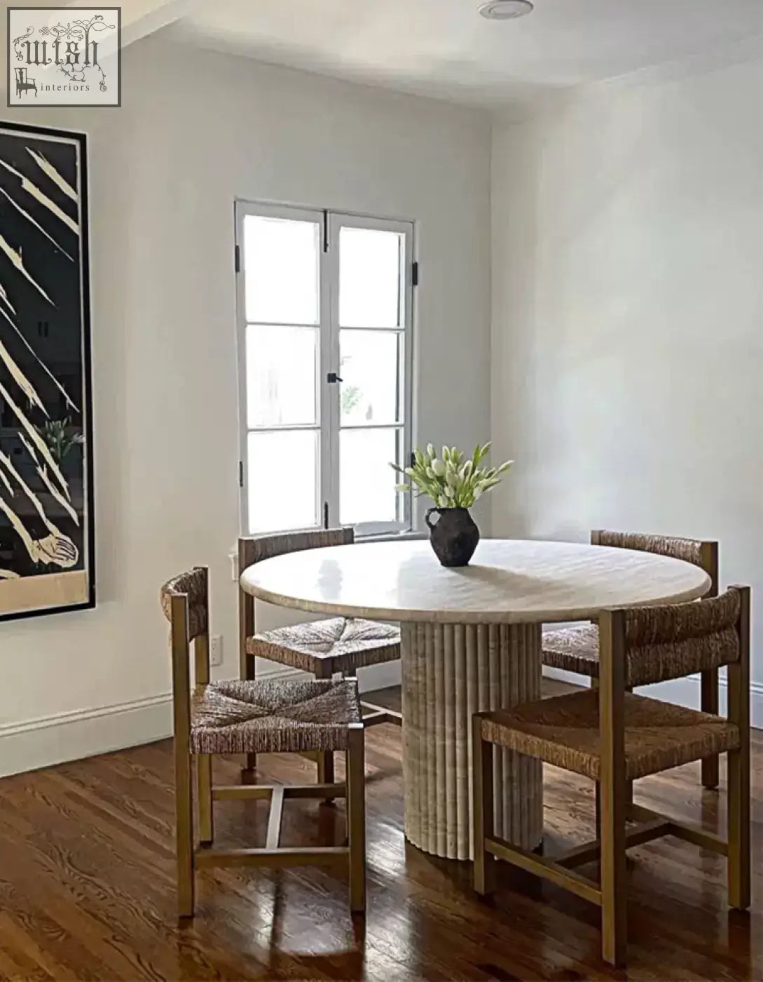 Round dining table callista with marble top and light wooden fluted base paired with woven wicker chairs