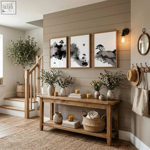 Rustic wooden console table with two shelves holding vases books candles and woven basket under calming wall art set of 3