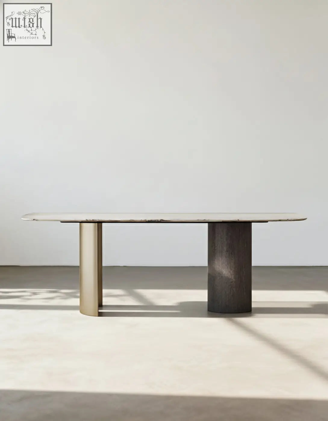 Minimalist cameron marble dining table with light marble top and contrasting brass and dark wood cylindrical legs