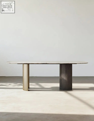 Minimalist cameron marble dining table with light marble top and contrasting brass and dark wood cylindrical legs