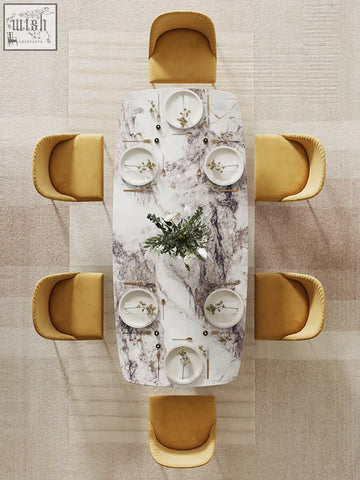Cameron marble dining table with a marble-patterned top surrounded by six mustard-yellow upholstered chairs