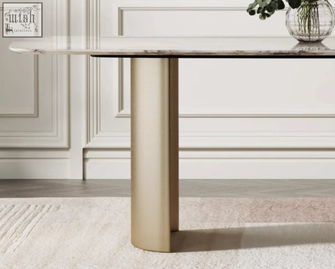 A sleek cameron marble dining table with a polished white marble top and a single gold finished cylindrical leg