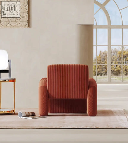 A rust-colored plush corduroy camilla armchair with rounded arms and a deep seat perfect for cozy seating and low shipping cost