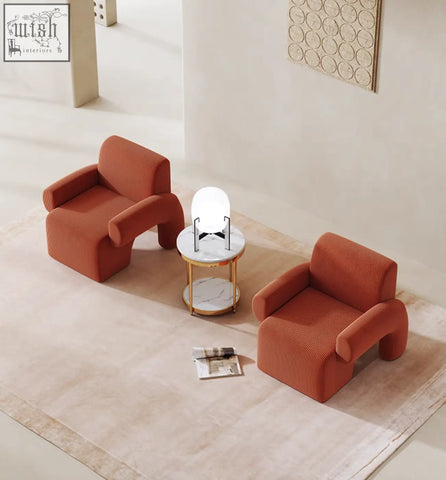 Two matching orange corduroy camilla armchairs with rounded sculptural forms and a deep seat perfect for relaxing