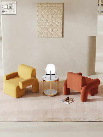 Yellow and orange upholstered camilla armchair with deep seat and rounded sculptural forms perfect for cozy seating