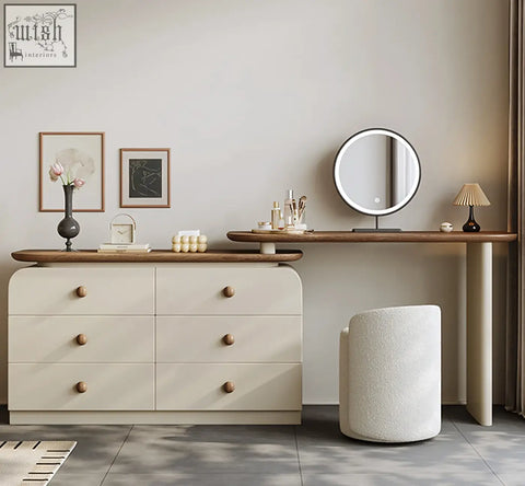Cream-colored wooden dressing table with chest of drawers and round knobs topped by matching wood vanity table