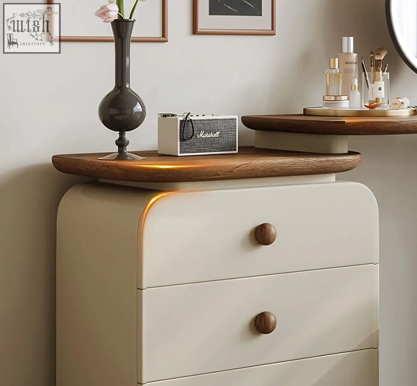 Cream-colored wooden dressing table with rounded drawers and wooden knobs topped by dark gray vase in campbell set