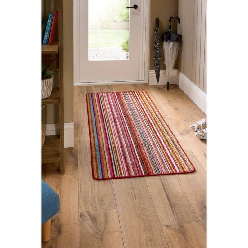 A colorful candy washable runner rug with red border and vertical pink orange blue green stripes perfect for easy care