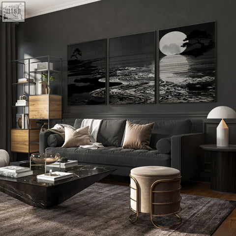 Dark gray upholstered sofa with beige and white throw pillows in living room with deep charcoal canvas pictures set of 3