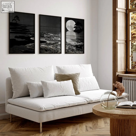 White upholstered sofa with metallic legs and cushions in living room with deep charcoal canvas pictures set of 3