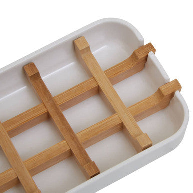 White ceramic soap dish with light brown bamboo grid bars perfect for holding white soap in style
