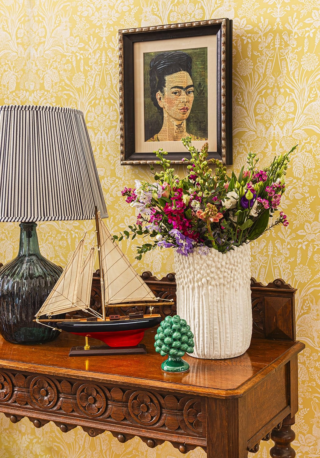 A white textured ceramic vase from cape cod sailboat collection filled with a vibrant mixed flower bouquet
