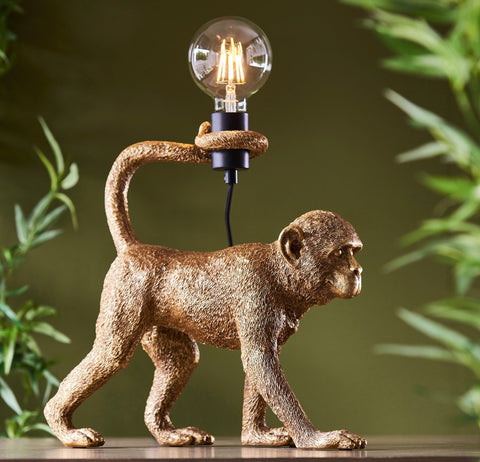 Bronze capuchin table lamp with a clear glass bulb on its back featuring matt black accents for stylish lighting