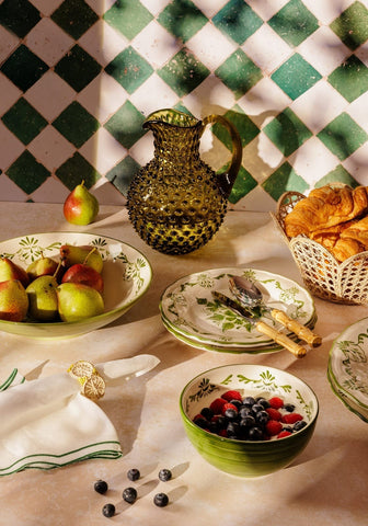 A textured olive green glass pitcher with hobnail pattern and curved handle perfect for cara shell dinner settings