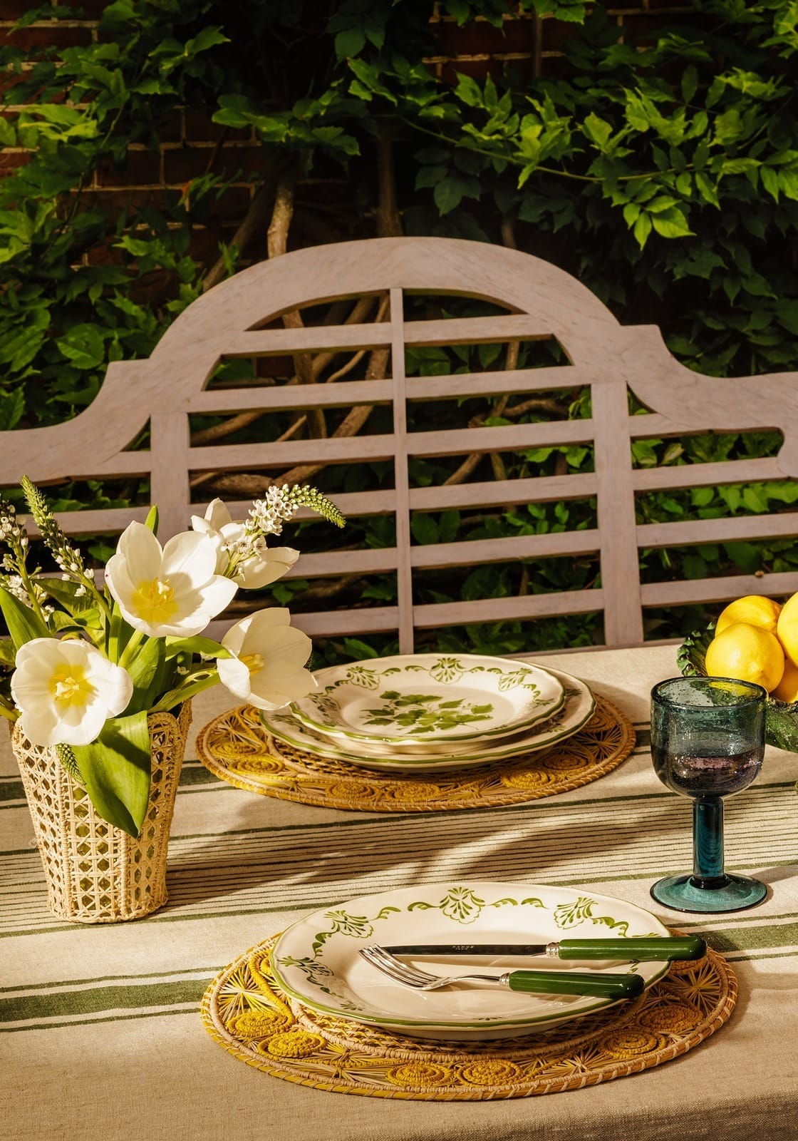 White ceramic cara shell side plate with green botanical pattern set on woven placemats for shell dinner use