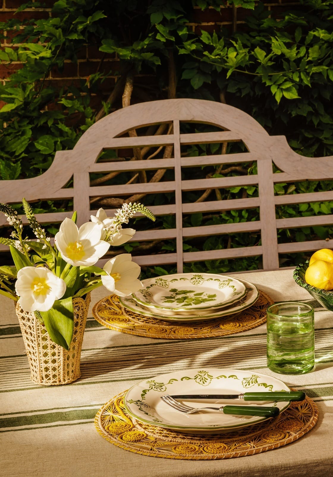 White ceramic cara shell side plate with green botanical pattern on woven placemat perfect shell dinner plate