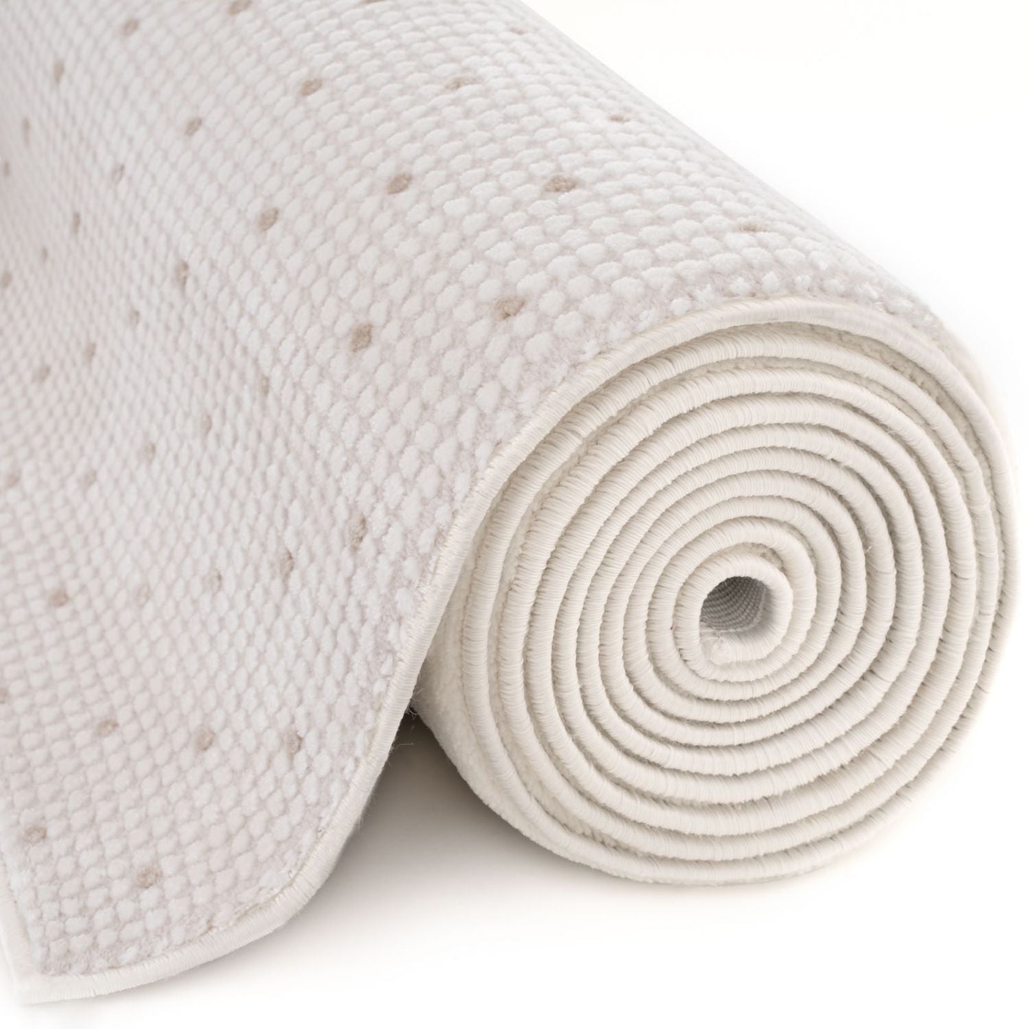 A rolled-up white memory foam mattress topper with a perforated surface shown with carmel cream-beige dots rug