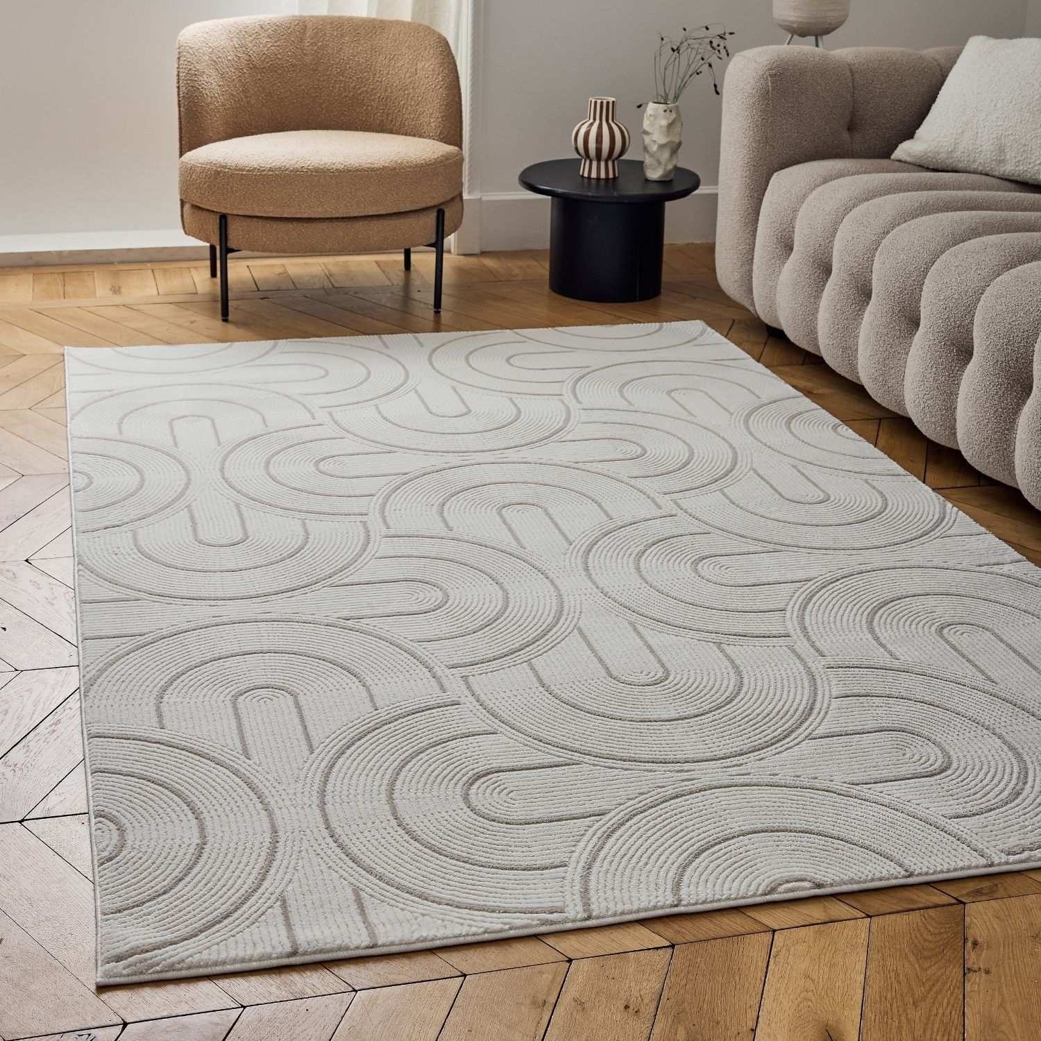 A light gray and cream beige geometric rug with a subtle raised pattern of interlocking curved lines perfect for any room